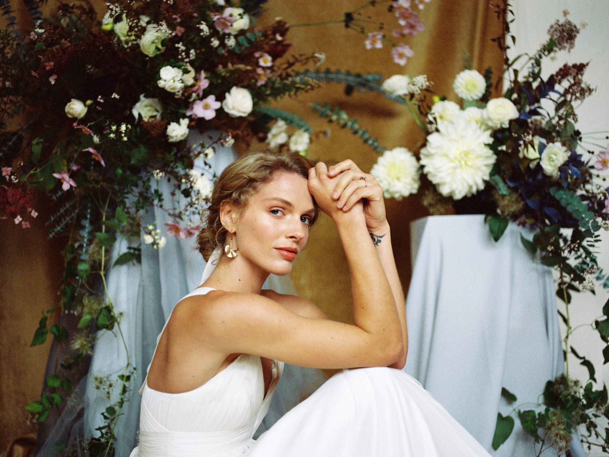 A serene bride lounging among a living floral installation by Selva Floral Design, with Makeup by Karen Cordell Artistry, wearing BHLDN from Brides with a Cause Portland