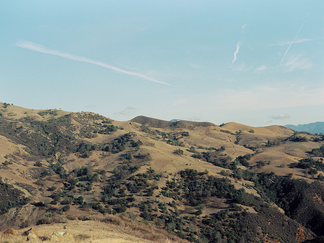 Blue skies and green rolling hills from Santa Barbara county shot on film by Santa Barbara film elopement photographer J.J. Au'Clair.
