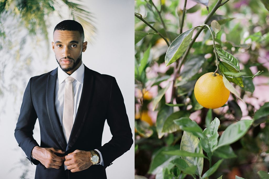 Dark groom with classic suit and champagne tie buttons his top button while featuring his classic watch surrounded by citrus trees and palm fronds in Santa Barbara's best wedding venue.